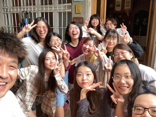 Eine Gruppe von Menschen, die mit ihren Händen das Friedenszeichen machen in der Unterkunft Tainan Guest House Hamuya in Tainan