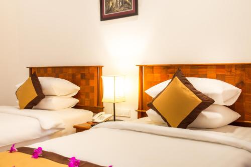 a hotel room with two beds and a phone at Glorious Hotel in Kompong Thom