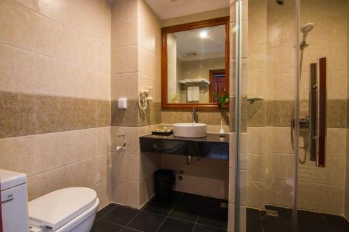 a bathroom with a toilet and a sink and a mirror at Glorious Hotel in Kompong Thom