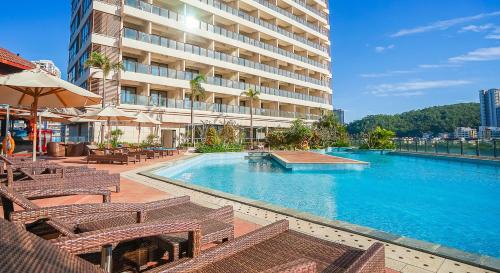 una gran piscina con sillas y un edificio en Crowne Plaza Sanya City Center, an IHG Hotel, en Sanya