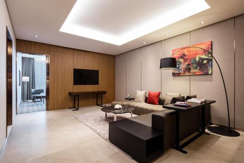 a living room with a couch and a tv at Ramada by Wyndham Seoul Sindorim in Seoul