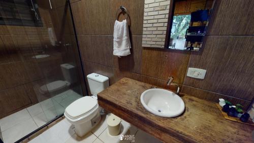 een badkamer met een toilet, een wastafel en een douche bij Pousada Villa Verde - Frente para a Praia do Farol in Ilha do Mel