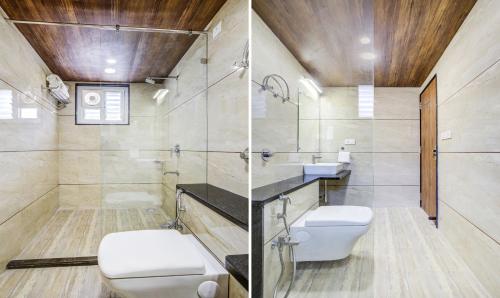 a bathroom with a toilet and a glass shower at Opulence Inn - 500 Meters From Railway Station in Udaipur