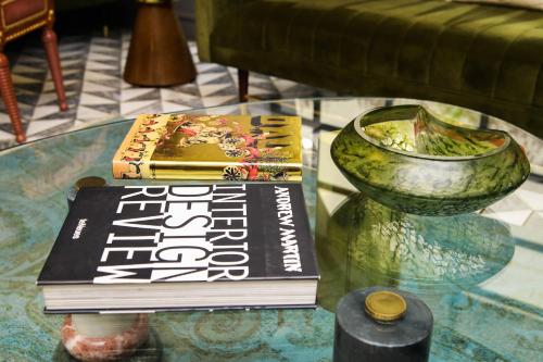 two books and a vase on a glass table at Ambiance Boutique Art Hotel Lahore in Lahore