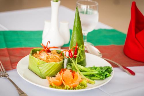 a plate of food with vegetables on a table at Glorious Hotel in Kompong Thom