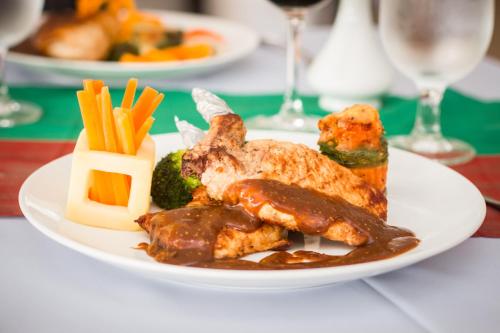 a plate of food with chicken and vegetables on a table at Glorious Hotel in Kompong Thom