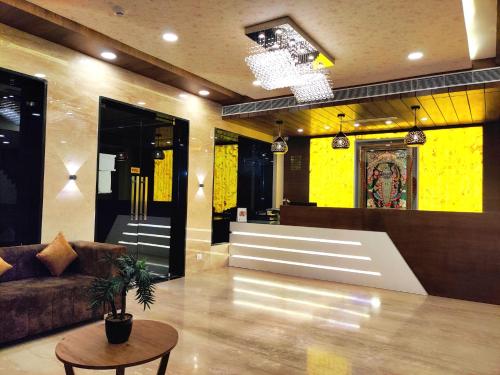 a lobby with a couch and a table and yellow walls at Treebo Trend Opulence Inn in Udaipur