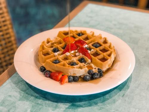 a plate of waffles with fruit on a table at Margaritaville Island Inn in Pigeon Forge