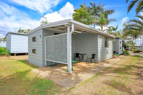 a small shed with a porch and a grill at Cane Village Holiday Park in Bundaberg