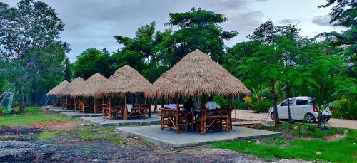 a group of tables with chairs and straw umbrellas at Glorious Hotel in Kompong Thom