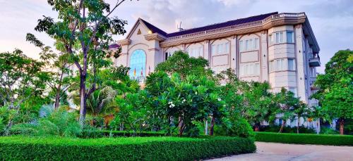 a large building with trees in front of it at Glorious Hotel in Kompong Thom