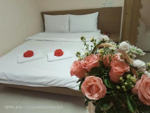 a bed with two towels and a bouquet of roses at ruamsab2 รวมทรัพย์2 in Ban Na Song