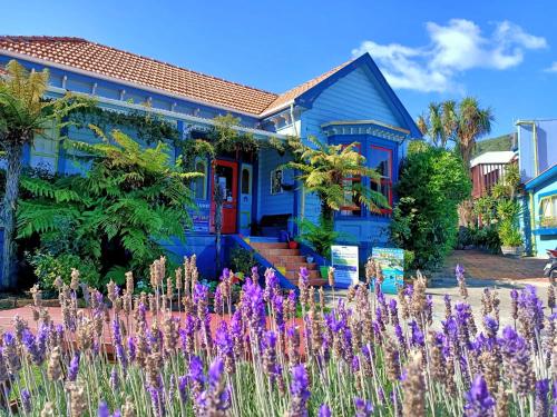 a blue house with purple flowers in front of it at The Villa in Picton