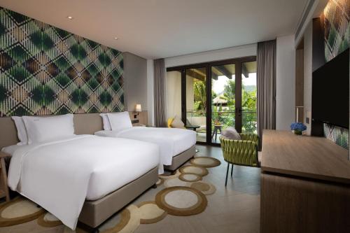 pokój hotelowy z 2 łóżkami i telewizorem w obiekcie Holiday Inn Resort Qionghai Guantang, an IHG Hotel w mieście Qionghai