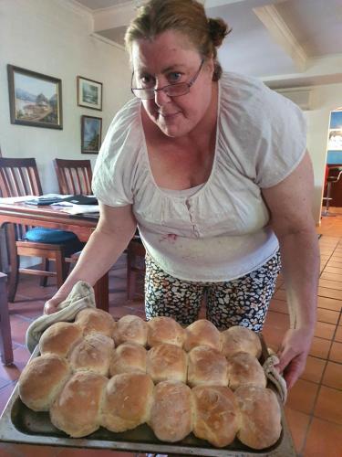 a woman standing in front of a tray of bread at Oaktree Guest House in Narbethong