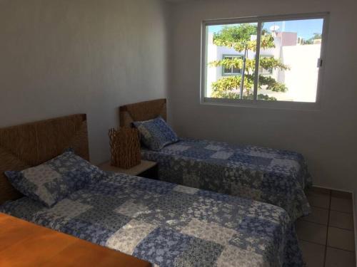 a room with two beds and a window at House with Pool near the Beach CTE69 in Mezcales