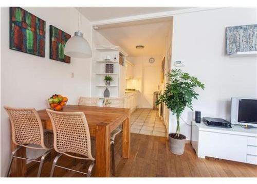 a kitchen and dining room with a wooden table and chairs at Vakantiehuis Katwijk in Katwijk