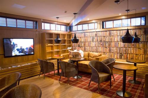 a man sitting on a couch in a library at Finlandia Hotel Isovalkeinen in Kuopio