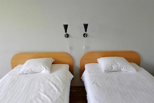 two beds are next to each other in a bedroom at Finlandia Hotel Isovalkeinen in Kuopio