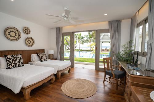 メナムにあるMiskawaan Villa Waterlilyのベッドルーム1室(ベッド1台、ソファ、テーブル付)