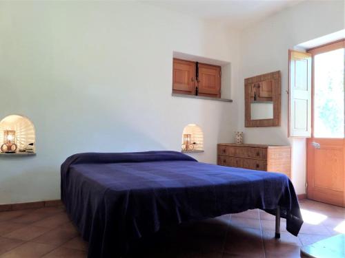 a bedroom with a bed with a blue blanket at Case al Mare - terrazzi panoramici e ampio giardino in Santa Marina Salina
