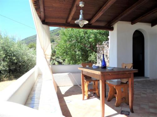 a wooden table on the patio of a house at Case al Mare - terrazzi panoramici e ampio giardino in Santa Marina Salina