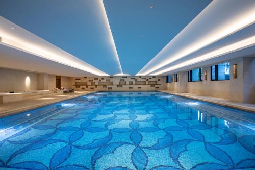 a swimming pool in a building with a blue floor at Crowne Plaza Fuzhou South by IHG in Fuzhou