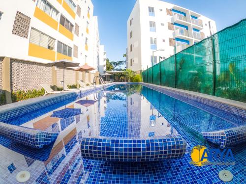 a swimming pool with blue tiles on the side of a building at Disfruta Vallarta, lindo departamento, gran ubicación alberca, nuevo in Puerto Vallarta