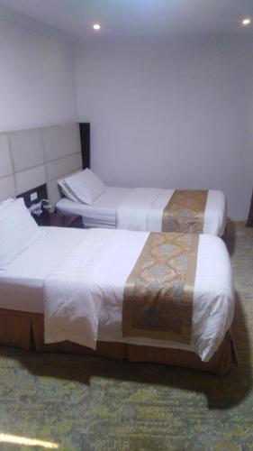 Habitación de hotel con 2 camas y mesa en بفن للشقق المخدومة Puffin Serviced Apartments en Al Jubail