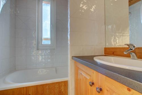 une salle de bain avec une baignoire et un lavabo dans l'établissement LODGE 8, à Morzine