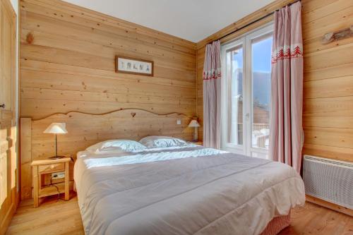 a bedroom with a bed and a large window at LODGE 8 in Morzine