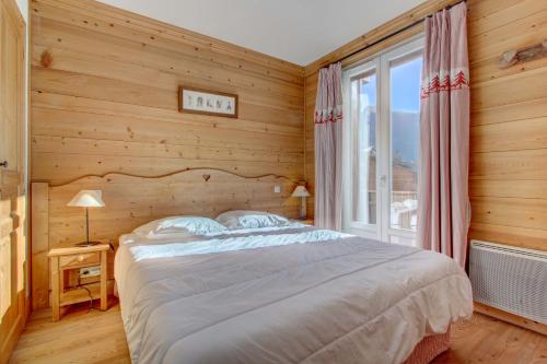 une chambre avec un lit et une grande fenêtre dans l'établissement LODGE 8, à Morzine