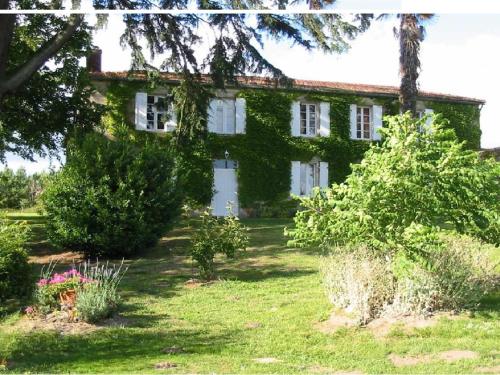 Une vieille maison avec du lierre sur elle dans l'établissement Chambres d'Hôtes Domaine du Bouchon, à Gans