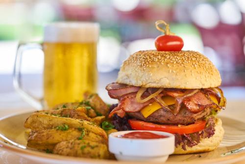 a hamburger and french fries and a bottle of beer at Avantis Suites Hotel in Eretria