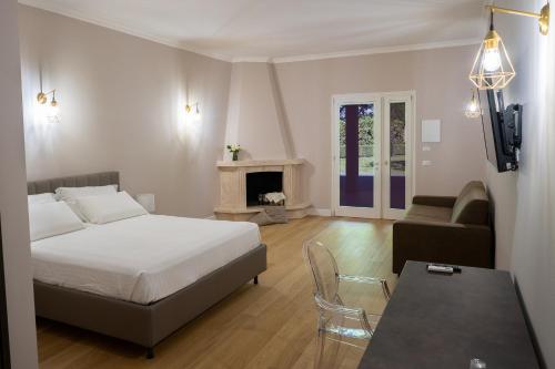 - une chambre avec un lit, un canapé et une cheminée dans l'établissement La Tenuta di Rocca Bruna Country Resort, à Tivoli