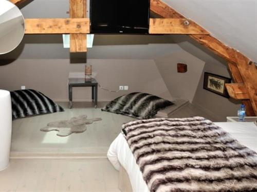 een slaapkamer met een groot bed en een zebraebra-deken bij Lodges Lao in Bully