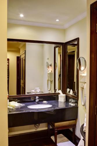 a bathroom with a sink and a large mirror at Pearl Continental Hotel, Lahore in Lahore