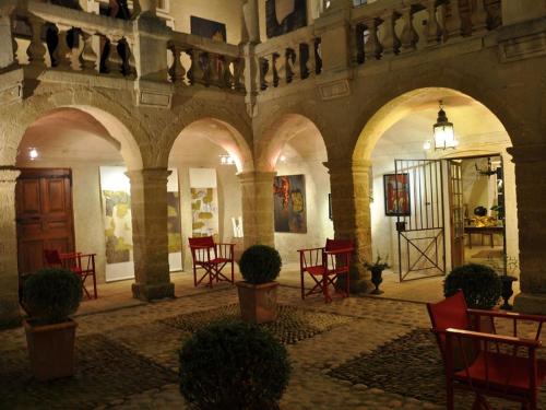 聖洛朗代阿爾布雷的住宿－堡布里山莊商會酒店，大楼内一间设有红色椅子和桌子的房间