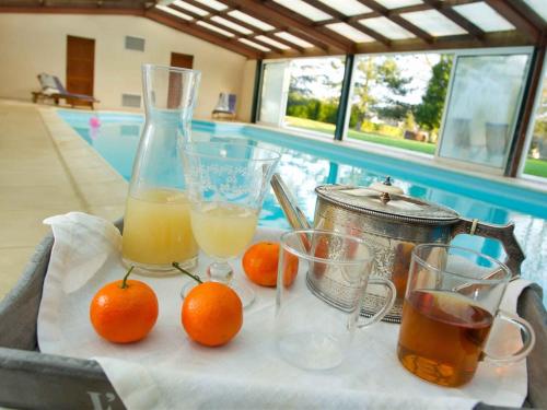 une table avec des oranges et des verres de jus d'orange dans l'établissement Le Sous-bois B&B, à Moyenneville