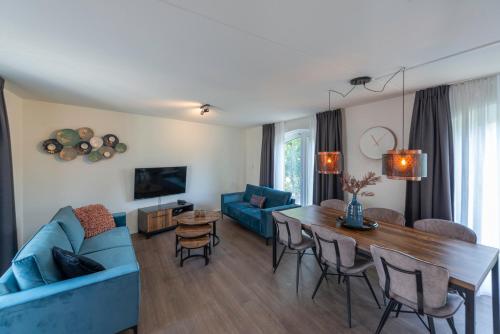 a living room with a blue couch and a table at Resort Citta Romana in Hellevoetsluis