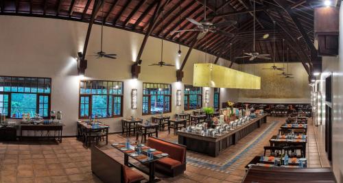 an image of a restaurant with tables and chairs at Club Mahindra Madikeri, Coorg in Madikeri