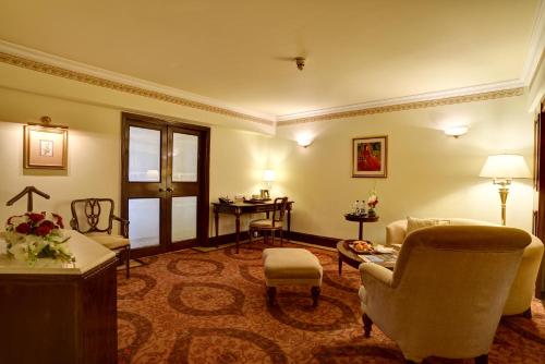 a living room with a couch and chairs and a table at Pearl Continental Hotel, Lahore in Lahore