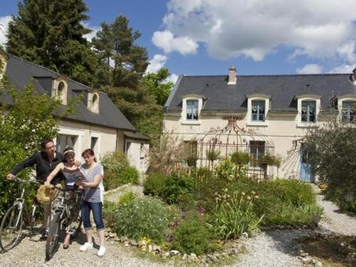 un homme et une femme avec un vélo devant une maison dans l'établissement Les Roses de Montherlant, à Montherlant