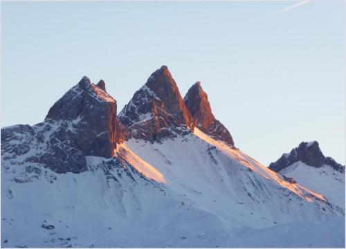 a snow covered mountain with the sun shining on it at Gîte clair, spacieux et cosy avec vue sur le massif de la Chartreuse in Sainte-Hélène-du-Lac