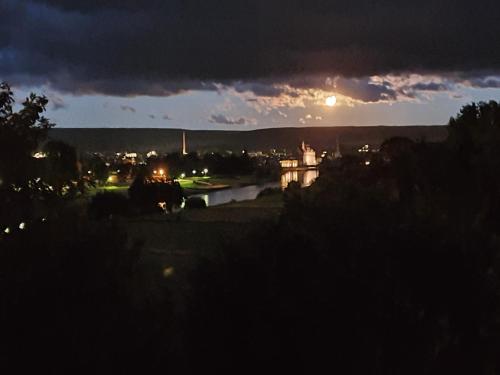 a view of a city at night with the moon at Hotel Kiekenstein in Stahle