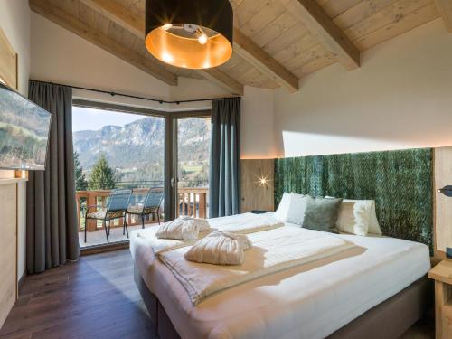 a bedroom with a large bed and a large window at Chalets Weitblick Mariasteinerhof in Mariastein
