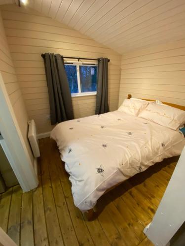 1 dormitorio con 1 cama en una habitación con ventana en Cherry Tree Glamping en Stroud