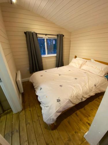 um quarto com uma cama num quarto com uma janela em Cherry Tree Glamping em Stroud