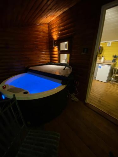 bañera en una habitación con piscina azul en Cherry Tree Glamping, en Stroud
