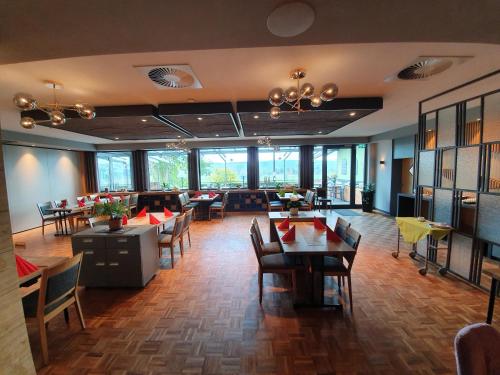 a restaurant with tables and chairs and windows at Hotel Kiekenstein in Stahle